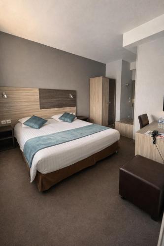a hotel room with a large bed and a chair at Logis - Hôtel du Nord et Restaurant La Table d'Elisa in Compiègne
