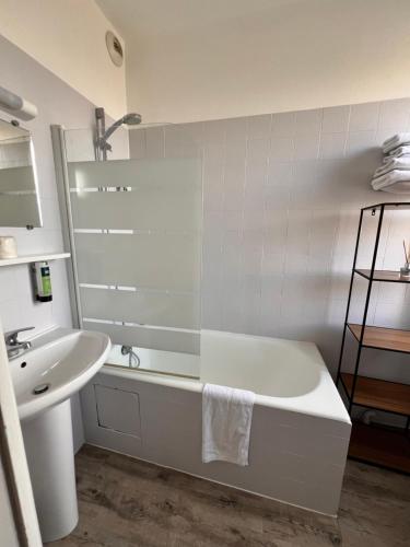 a white bathroom with a tub and a sink at Logis - Hôtel du Nord et Restaurant La Table d'Elisa in Compiègne