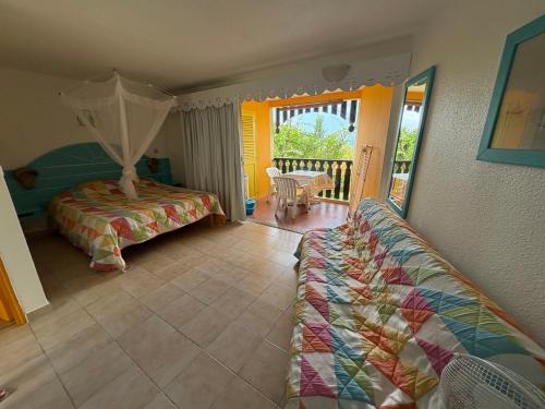 a bedroom with a bed and a balcony at Ti' Cocon Caritan in Sainte-Anne