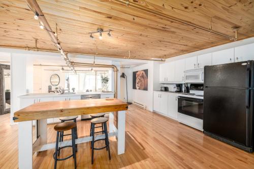 a kitchen with a table and a black refrigerator at Lion's Den // Spacious 1500 sqft (2 WC) - Downtown in Quebec City