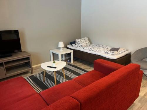 a living room with a red couch and a tv at Apartment Annalantie in Pyhäjoki