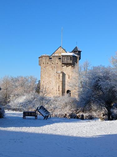 a building in the snow with a bench in front at Domaine de la Ferté Clairbois in Sainte-Suzanne