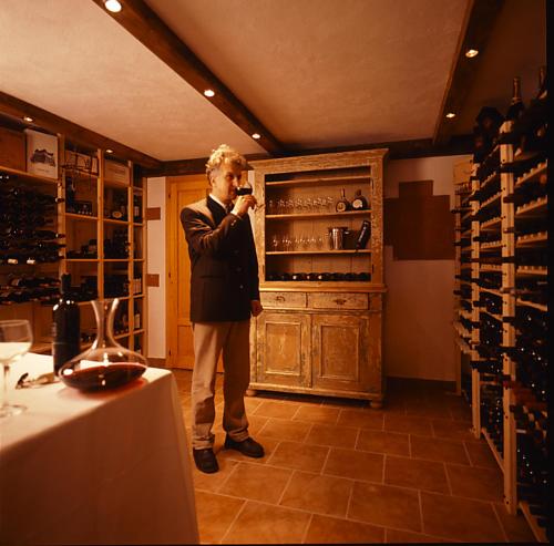
a man standing in front of a counter in a kitchen at Dolomiti Hotel Cozzio in Madonna di Campiglio
