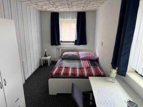 a small room with two beds and a desk at Zimmervermietung Kimberly in Bischbrunn