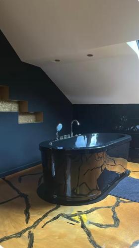 a bathroom with a black tub in a room at Love Room in Canteleu