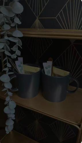 three cups sitting on a shelf in a room at Love Room in Canteleu
