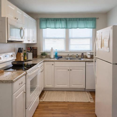a kitchen with white cabinets and a white refrigerator at The Rustic Retreat- close to downtown in Bristol
