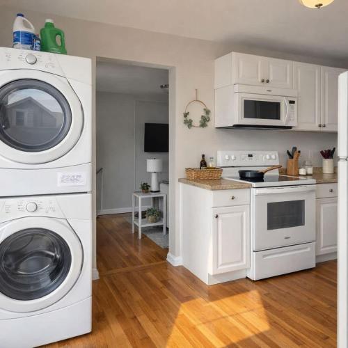 a kitchen with white cabinets and a washer and dryer at The Rustic Retreat- close to downtown in Bristol