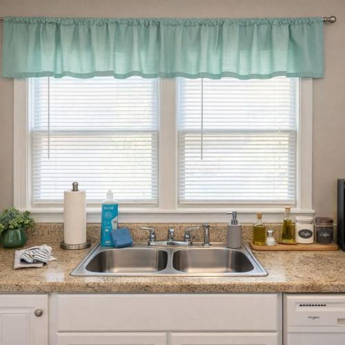a kitchen counter with a sink and two windows at The Rustic Retreat- close to downtown in Bristol