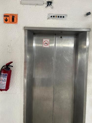 a metal elevator with a no smoking sign on it at Hotel San Francisco in Villahermosa