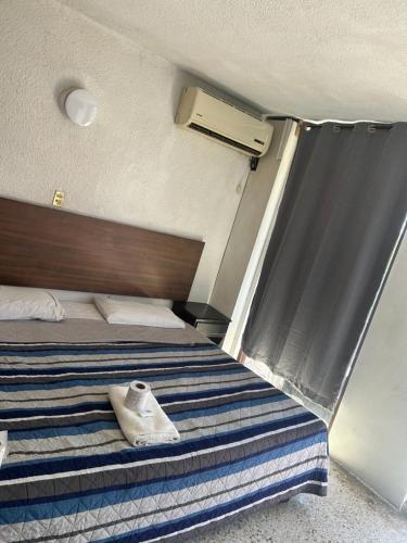 a bedroom with a bed with a towel on it at Hotel San Francisco in Villahermosa