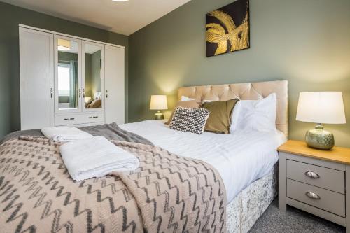 a bedroom with a large bed with white sheets and pillows at 61 Deneside in Lanchester