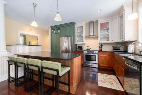 a kitchen with green cabinets and a black counter top at Pine Trace Escape in Glen Arbor in Glen Arbor