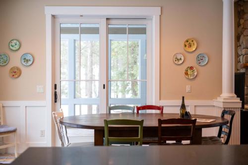 a dining room with a table and chairs and a glass door at Pine Trace Escape in Glen Arbor in Glen Arbor