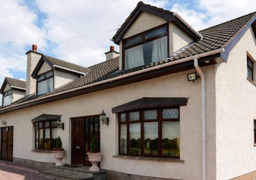 a house with large windows and a roof at Sleepy Hollow Apartment in Cushendun