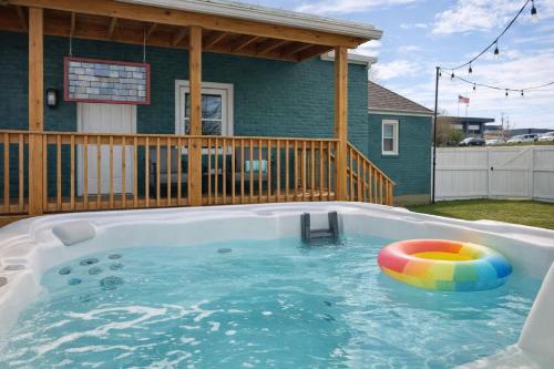 a pool with a ball in the water in front of a house at Honeybee Bungalow with Hot Tub in Bristol