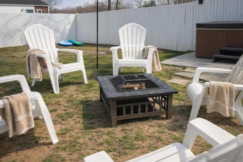 three white chairs and a fire pit in a yard at Honeybee Bungalow with Hot Tub in Bristol