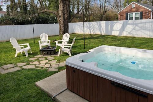 a hot tub in a yard with two chairs and a table at Honeybee Bungalow with Hot Tub in Bristol