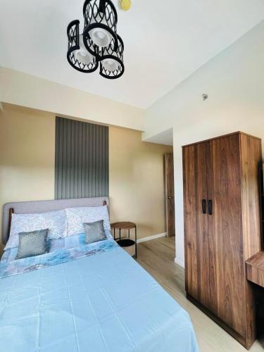 a bedroom with a blue bed and a chandelier at KEY REALTY SERVICES Ph in Pajak