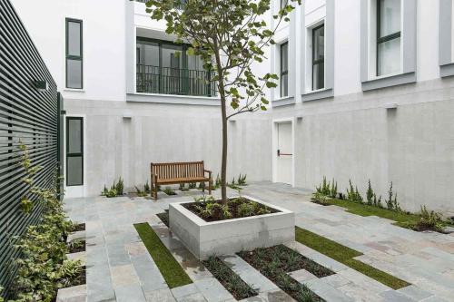 a bench sitting in front of a building with a tree at Bohemian Barranco Apartments by Geko in Lima