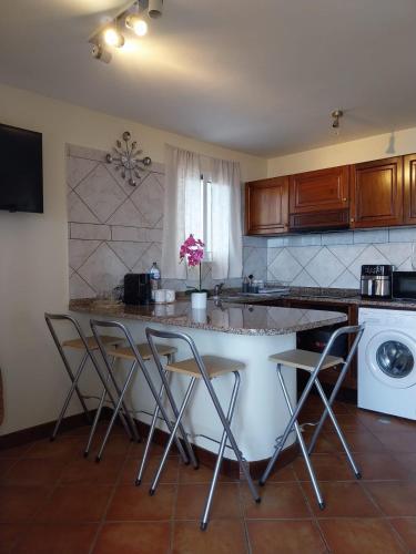 a kitchen with a counter with stools in it at Casa Do Pico in São Vicente