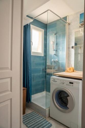 a washing machine in a bathroom with a shower at Doux Pavillon - Le Patio in Nice