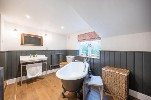 a bathroom with a large tub and a sink at Hollyhocks, Tunstall in Tunstall
