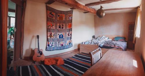 a bedroom with a bed and a guitar in it at tausend plus eine nacht in Vöhl