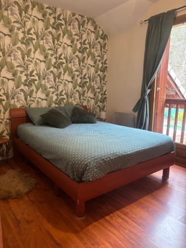 a bed in a room with a wall at Chambre Boscodon in Savines