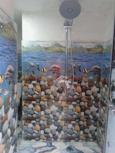 a bathroom with a shower with a painting on the wall at Tea Leaf Family Cottage in Bandarawela