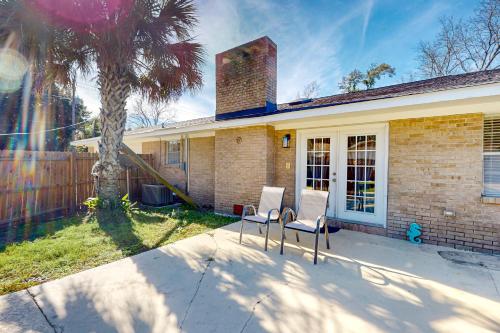 a house with two chairs in front of a palm tree at Poolside Bliss! Christian Pass Family Home w/ Yard in Long Beach