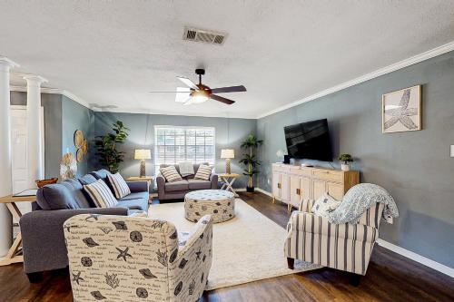a living room with a couch and a tv at Poolside Bliss! Christian Pass Family Home w/ Yard in Long Beach