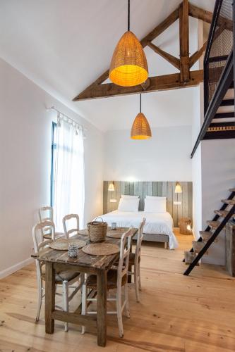 a room with a table and chairs and a bed at Welcôm Apparts-chic et intimiste-100m du Port in La Teste-de-Buch