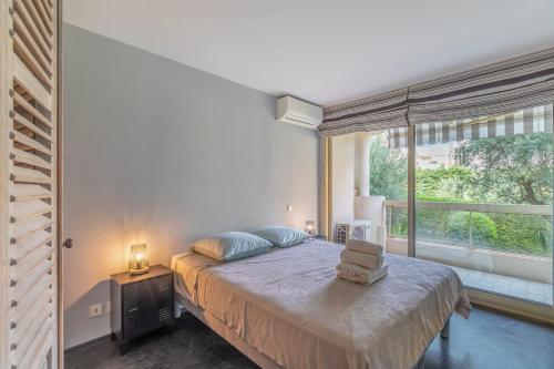 a bedroom with a bed and a large window at TANIT Piscine, 6 couchages, Parking in Antibes