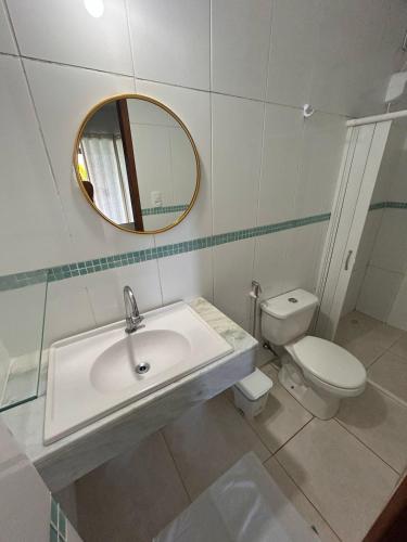 a bathroom with a sink and a toilet and a mirror at Angra dos reis Serra e Mar in Angra dos Reis