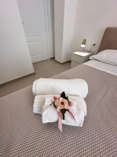 a bed with towels and a bouquet of flowers on it at Blu Parthenope a Spaccanapoli in Naples