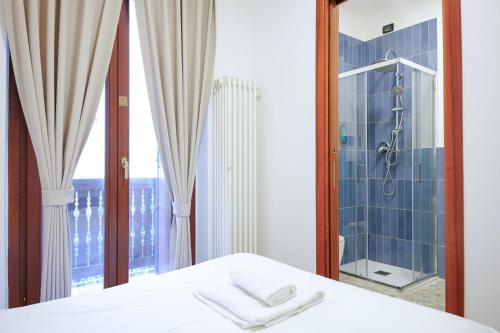 a bedroom with a shower and a bed and a window at Sunshine HOTEL in Mestre