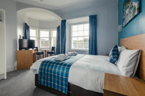 a bedroom with a bed and a desk in a room at The Caledonian Thistle Hotel in Callander