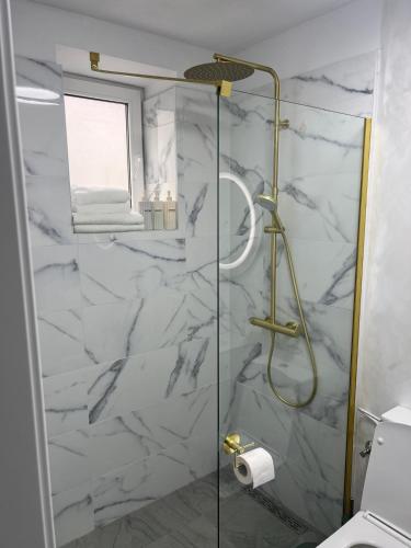 a bathroom with a shower with white marble at 7 min walking to airport in Otopeni