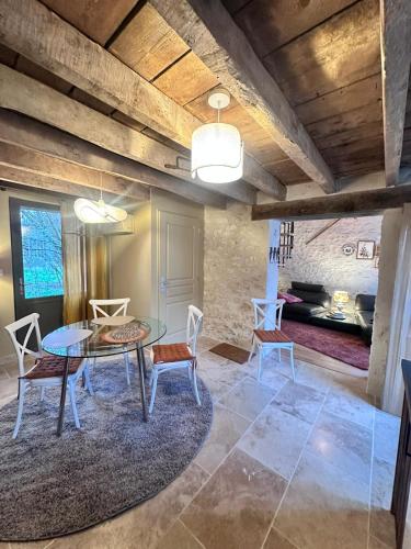 a dining room with a glass table and chairs at L'écurie du vigneron in Châtillon-sur-Cher