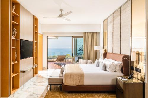 a hotel room with a bed and a television at Garza Blanca Sanctuary Puerto Vallarta in Puerto Vallarta