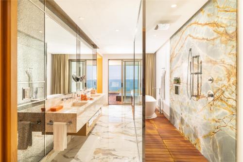 a bathroom with two sinks and a glass shower at Garza Blanca Sanctuary Puerto Vallarta in Puerto Vallarta