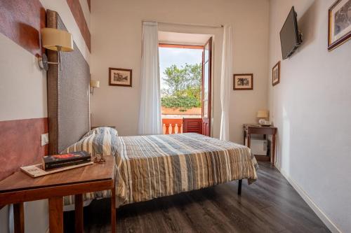 a bedroom with a bed and a table and a window at Al Bastione di Cagliari in Cagliari