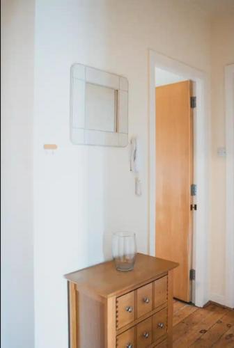a wooden dresser with a glass bowl on top of it at Causeyside apartment in Paisley