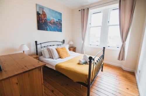 a bedroom with a bed and a window at Causeyside apartment in Paisley