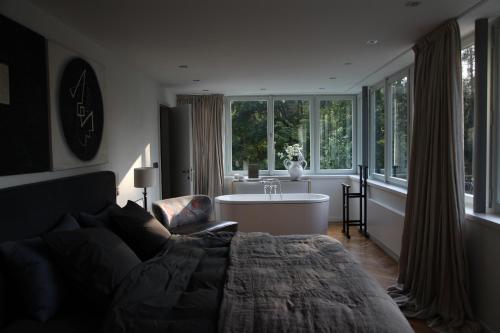 a living room with a couch and a bath tub at Villa Čisovice - Functionalist Retreat near Prague in Čisovice