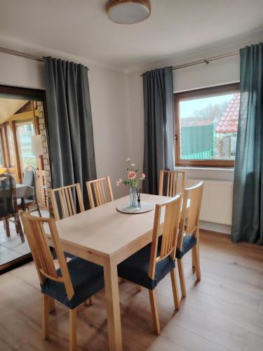 a dining room table and chairs with a vase of flowers on it at Ferienwohnung Am Wald in Bad Marienberg