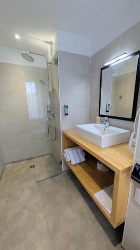a bathroom with a sink and a shower at Logis Hôtel restaurant La Remise in Le Bleymard