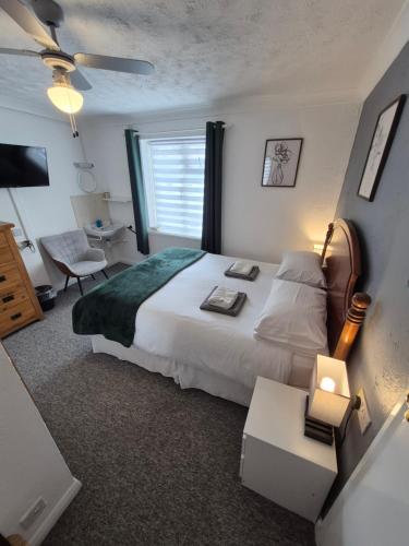 a bedroom with a large white bed and a window at The Clifton at Paignton in Paignton