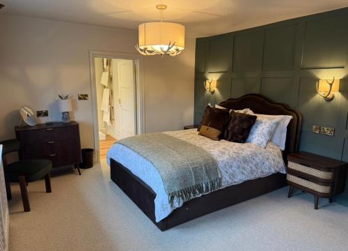 a bedroom with a large bed with a green wall at The Huntsman in Norwich
